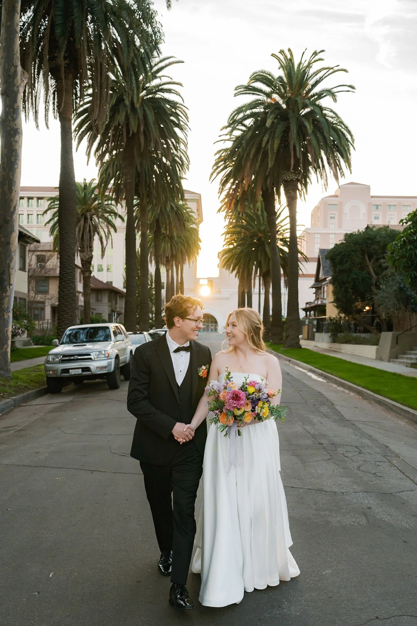 Bride and groom on palm-lined street