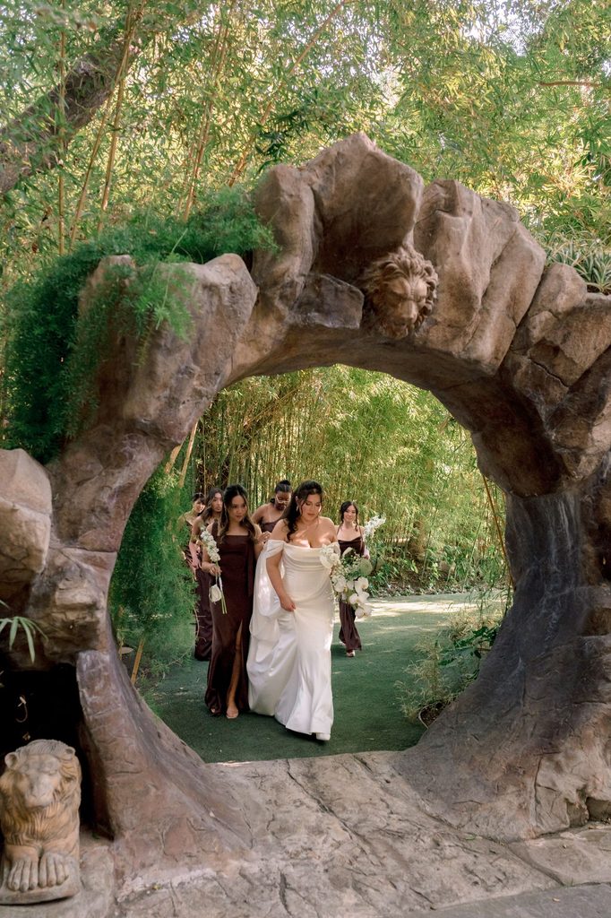 Bridesmaids gathered beneath the stone moon gate at Hartley Botanica