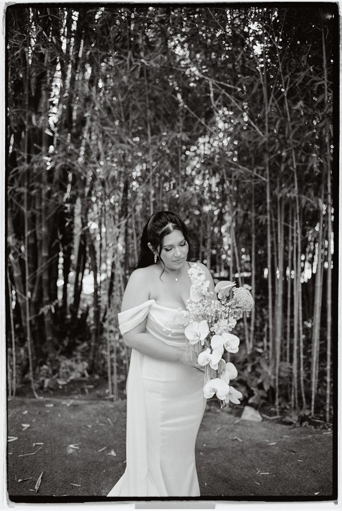 Bride with her orchid bouquet in the bamboo garden, black and white film portrait