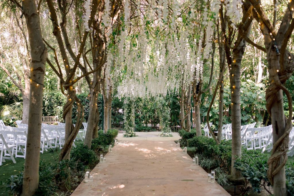 Ceremony aisle beneath hanging white blooms at Hartley Botanica in Somis, California