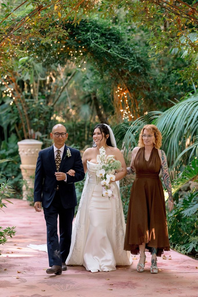Bride walking down the aisle with her parents at Hartley Botanica