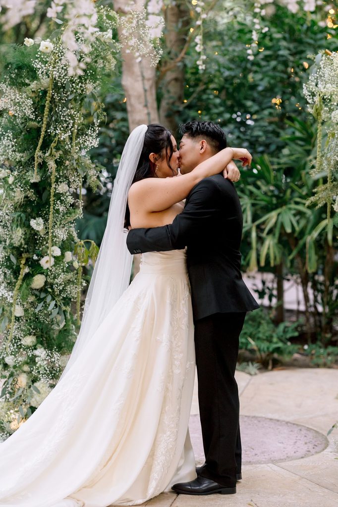 Bride and groom embrace at the altar after their first kiss