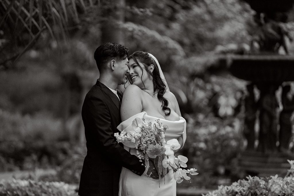 Bride and groom embracing in the garden, black and white