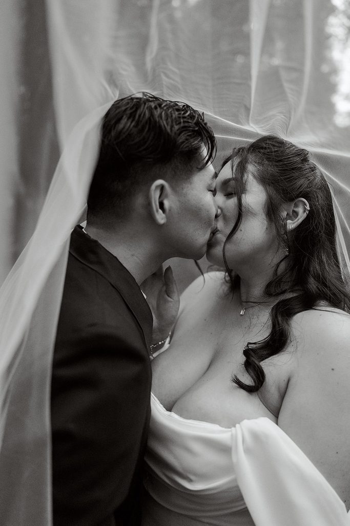 Kiss beneath the veil, black and white editorial portrait