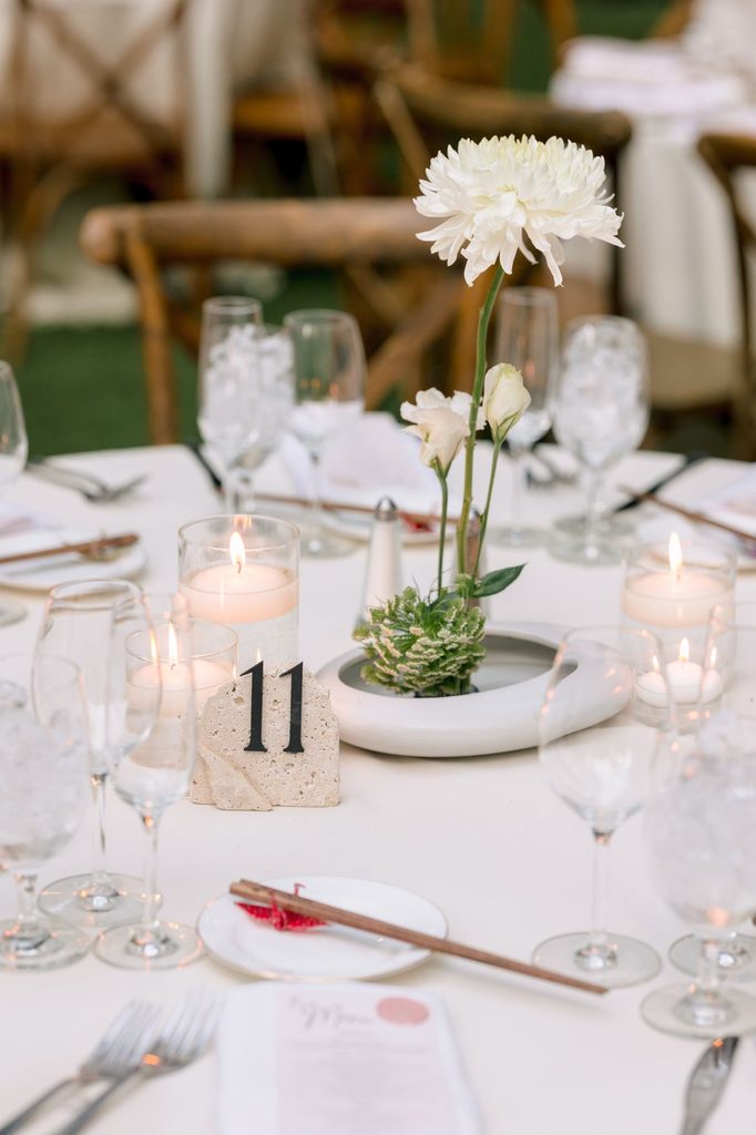 Reception table with white dahlia, candles and table number eleven
