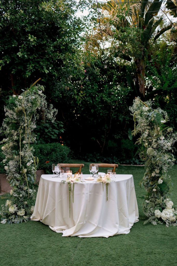 Sweetheart table draped in white among the garden greenery at Hartley Botanica