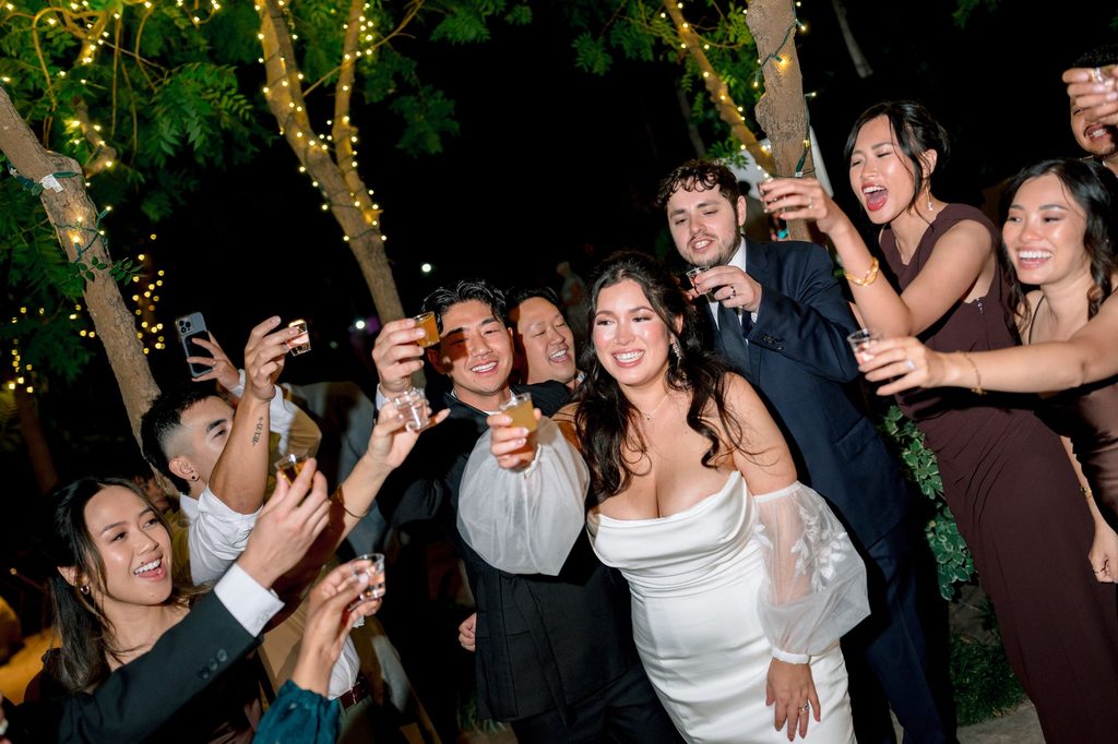 Wedding party cheering on the dance floor at Hartley Botanica